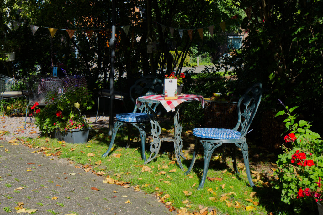 Tafels en stoelen in theetuin Bij Saar