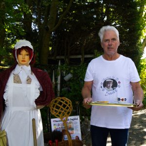 Eigenaar theetuin Bij Saar Wim Holkamp naast paspop met kostuum van Saartje